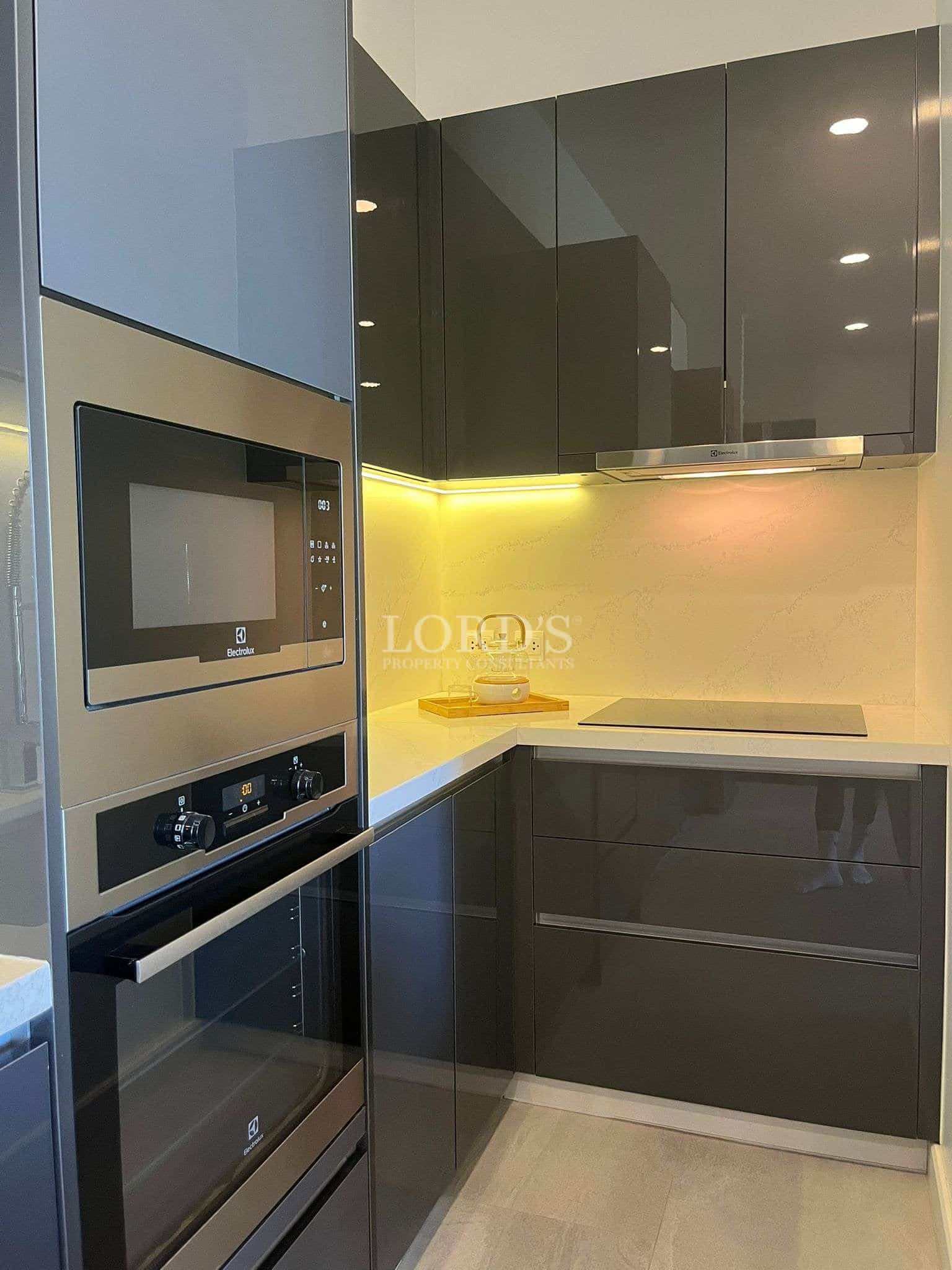 Modern kitchen with built-in oven, glossy cabinets, and under-cabinet lighting