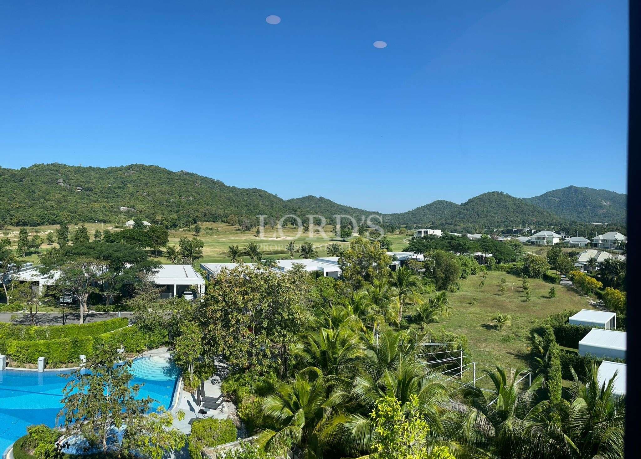 Panoramic view of luxury residential community with swimming pool and mountain landscape