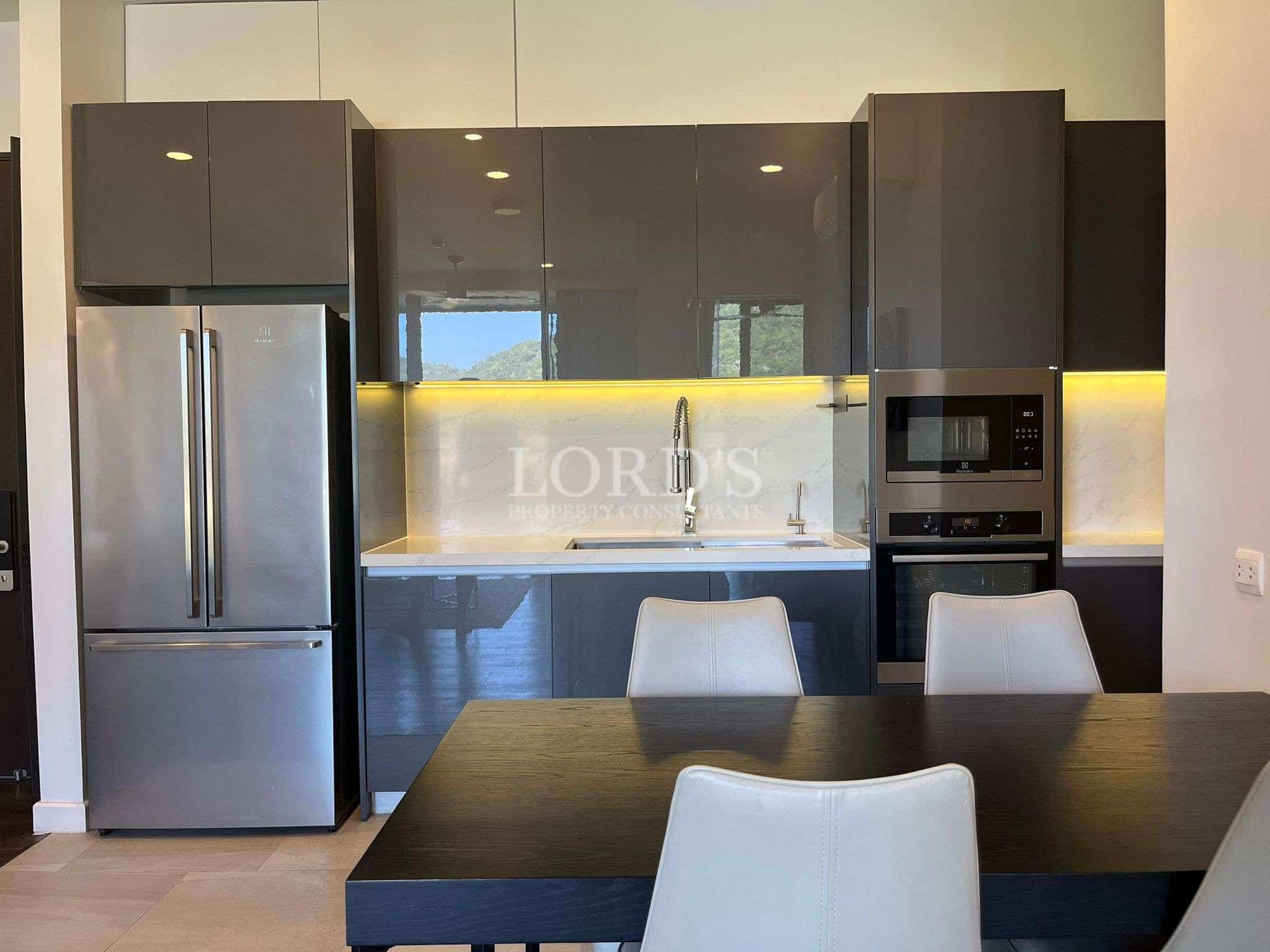 Modern kitchen with glossy grey cabinets, built-in oven and microwave, stainless steel fridge, and under-cabinet lighting