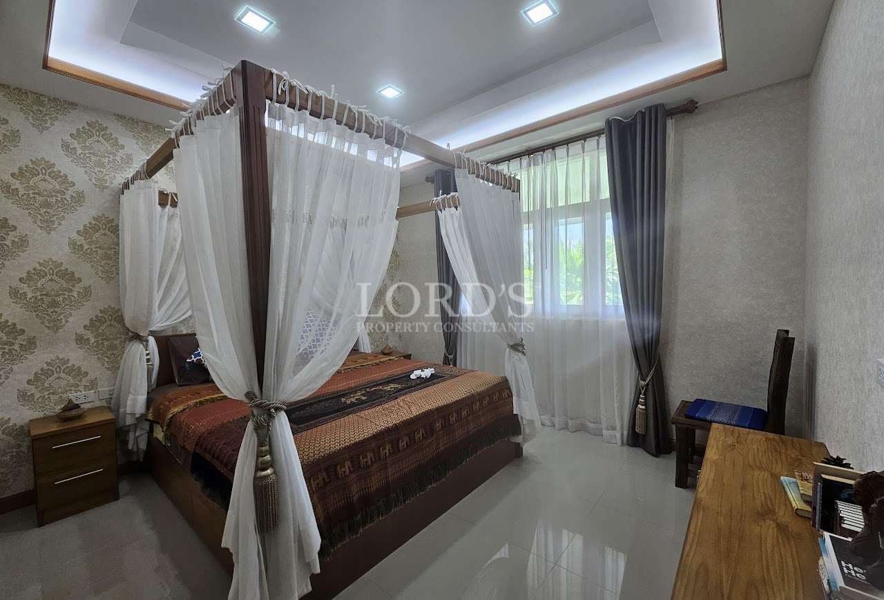 Elegant bedroom with four-poster bed, sheer canopy curtains, recessed ceiling lighting, glossy tiled floor, and large window with drapes