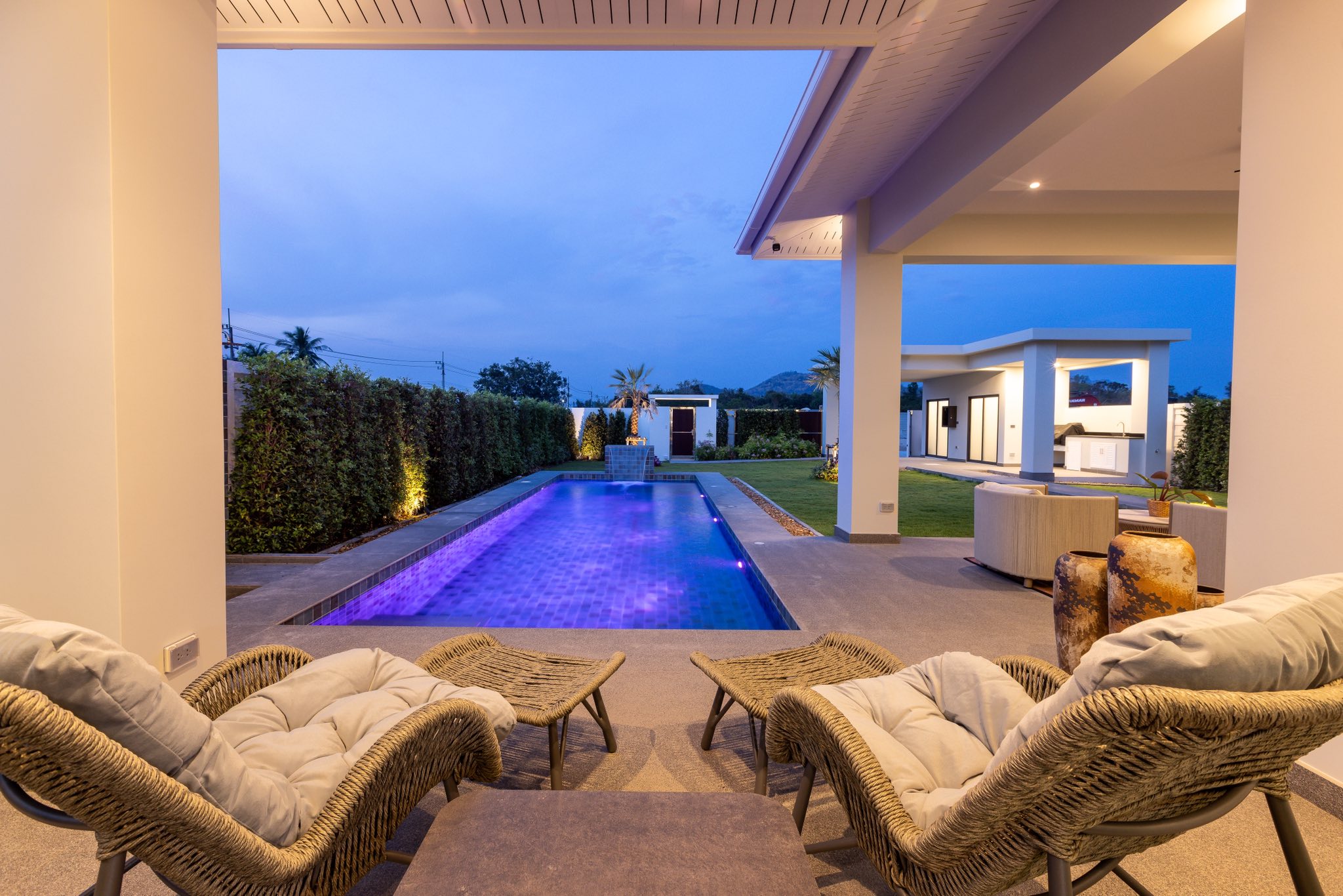 Luxury villa outdoor lounge with swimming pool and garden at evening