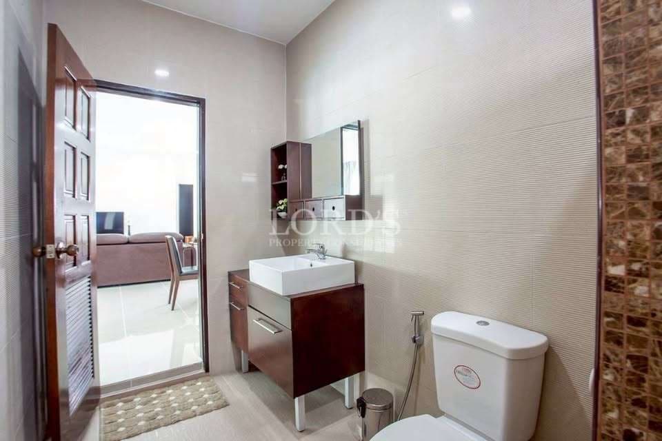 Modern bathroom with floating vanity, square sink, wall mirror, toilet, and neutral tiled walls