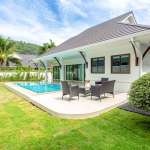 Modern single-story villa with private swimming pool, outdoor seating area, manicured lawn, and covered terrace