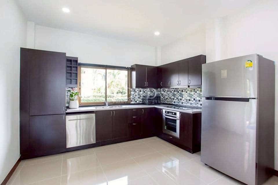 Modern kitchen with dark wood cabinets, stainless steel appliances, tiled backsplash, and large window