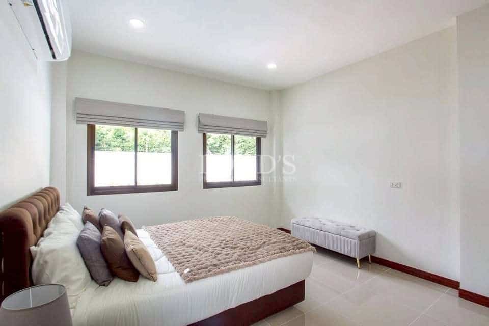 Minimalist bedroom with double bed, neutral tones, tiled floor, large windows, and air conditioning
