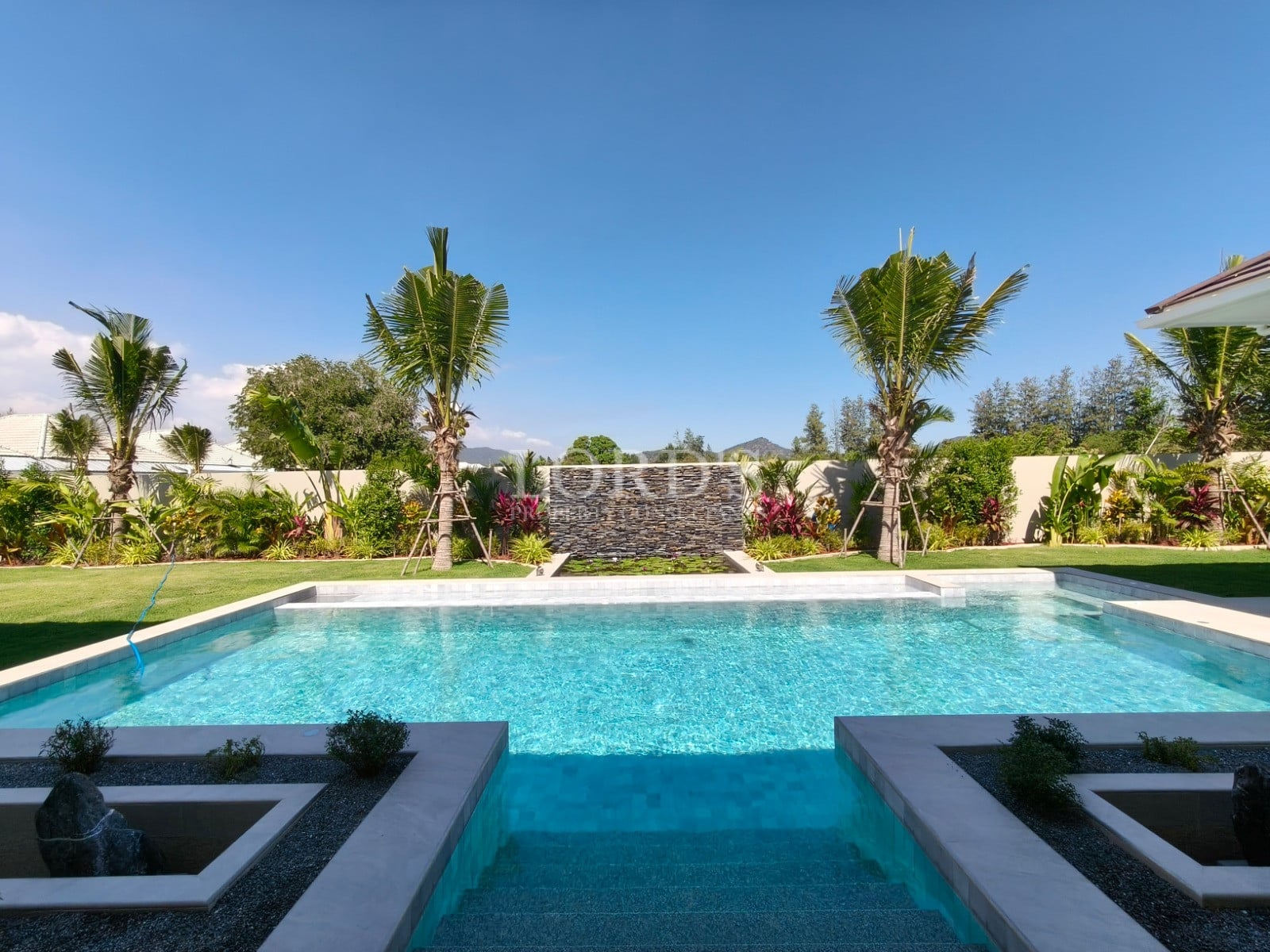 Luxurious pool surrounded by greenery.
