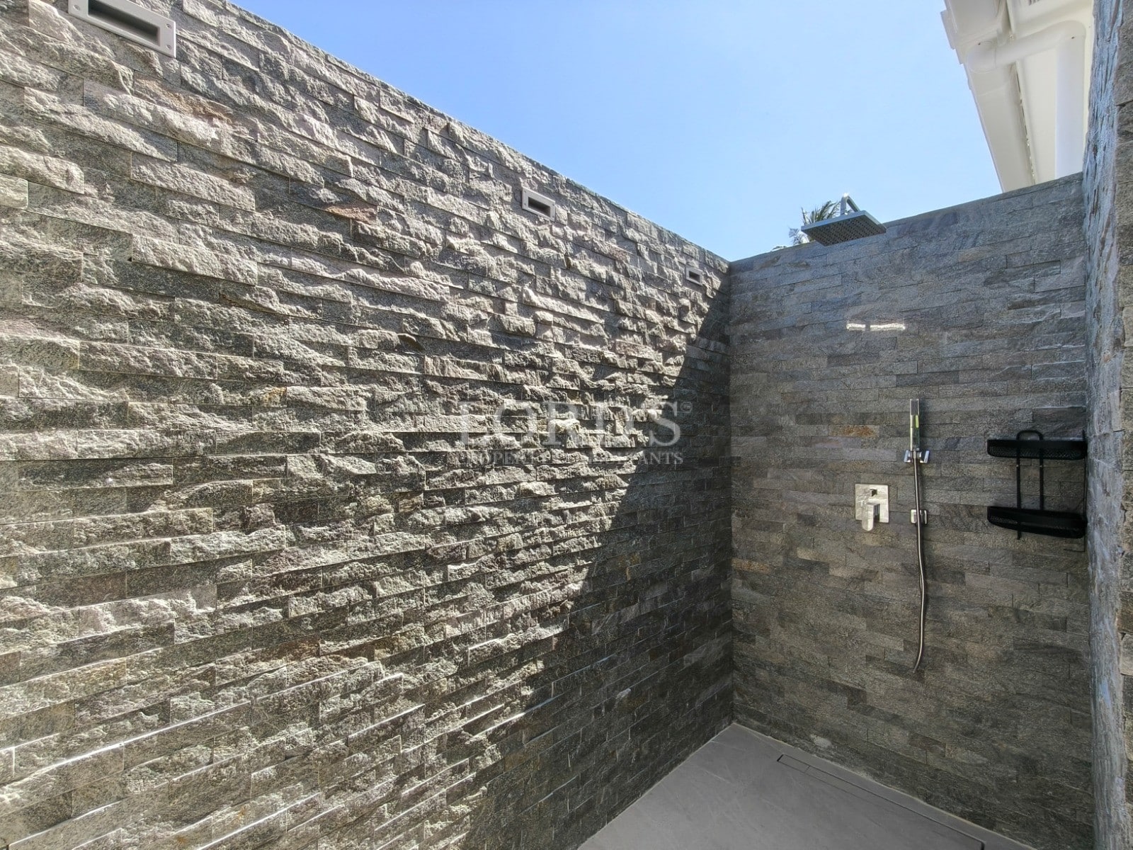 Outdoor stone shower with modern fixtures