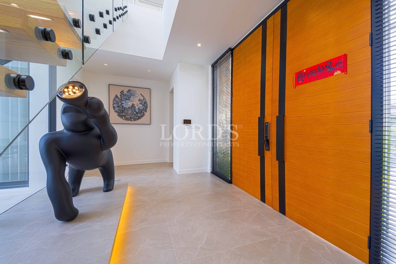 Moderner Villen-Eingang mit großen hölzernen Doppeltüren, Glastreppe und zeitgenössischer Skulptur.