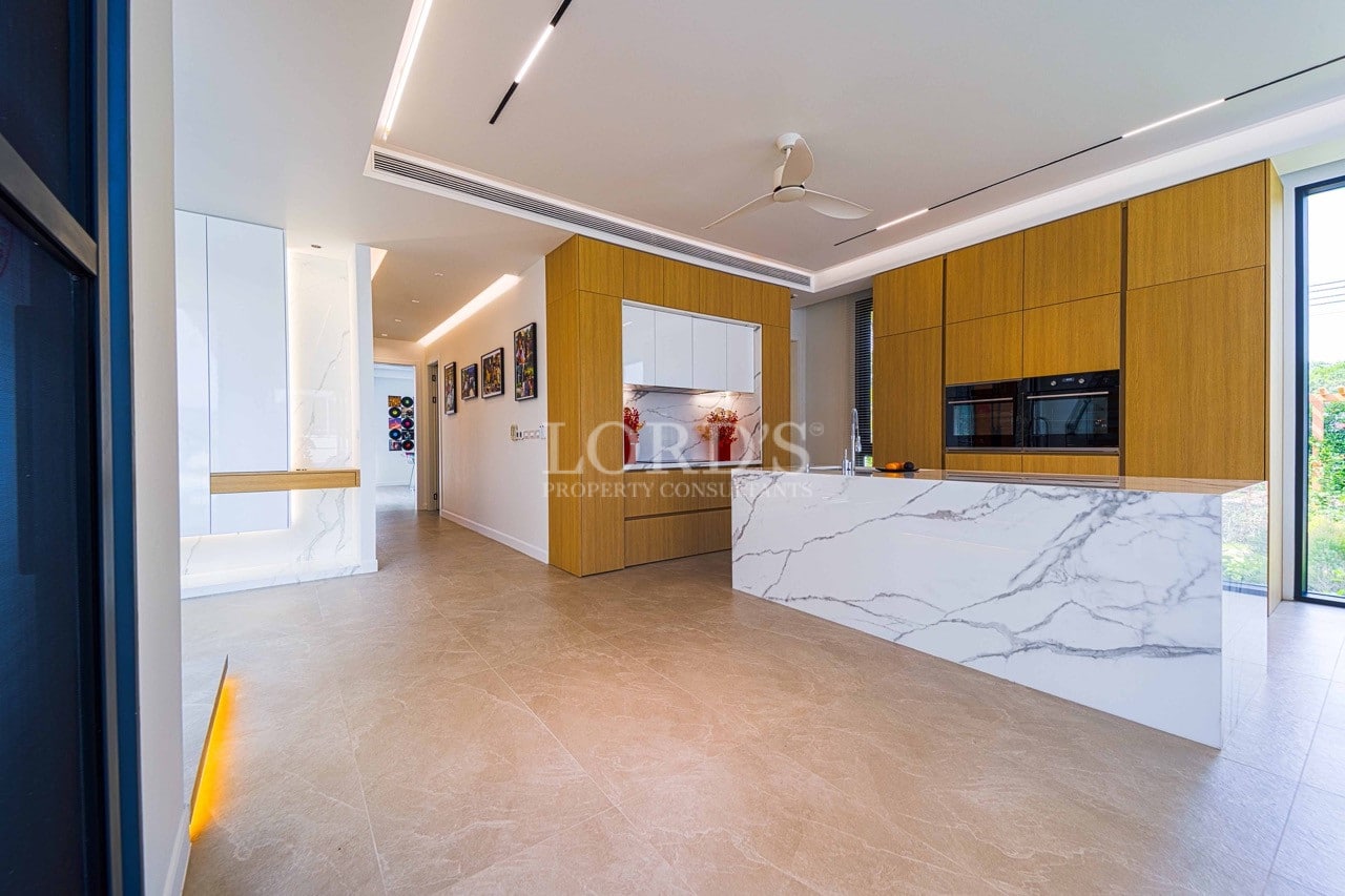 Moderne, offene Küche mit Marmorinsel, Holzschränken, Einbaugeräten und Deckenbeleuchtung.