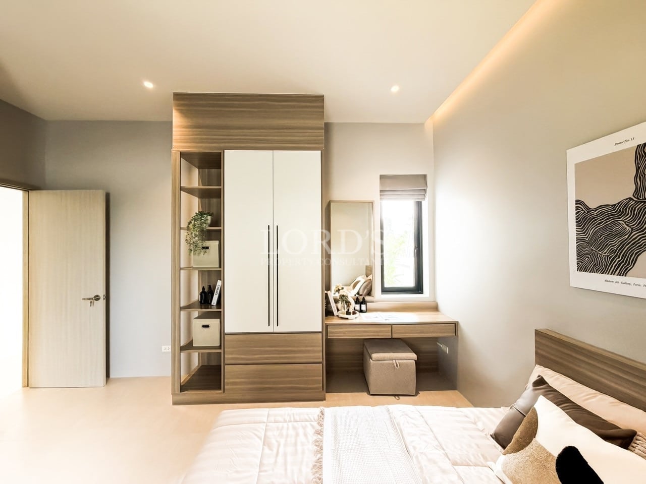 Modern bedroom with built-in wardrobe, vanity desk, and soft ambient lighting.