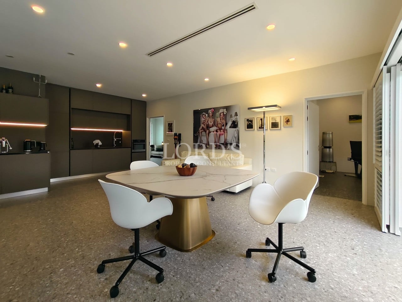 Modern dining area with designer chairs, open-plan living space, and sleek contemporary kitchen.