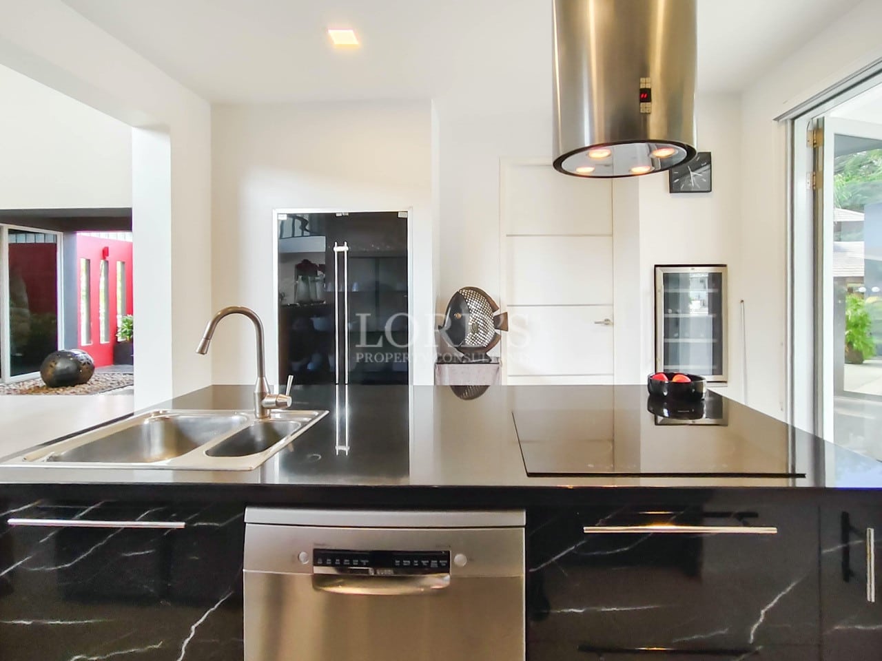 Modern kitchen island with black marble countertop and stainless steel appliances.