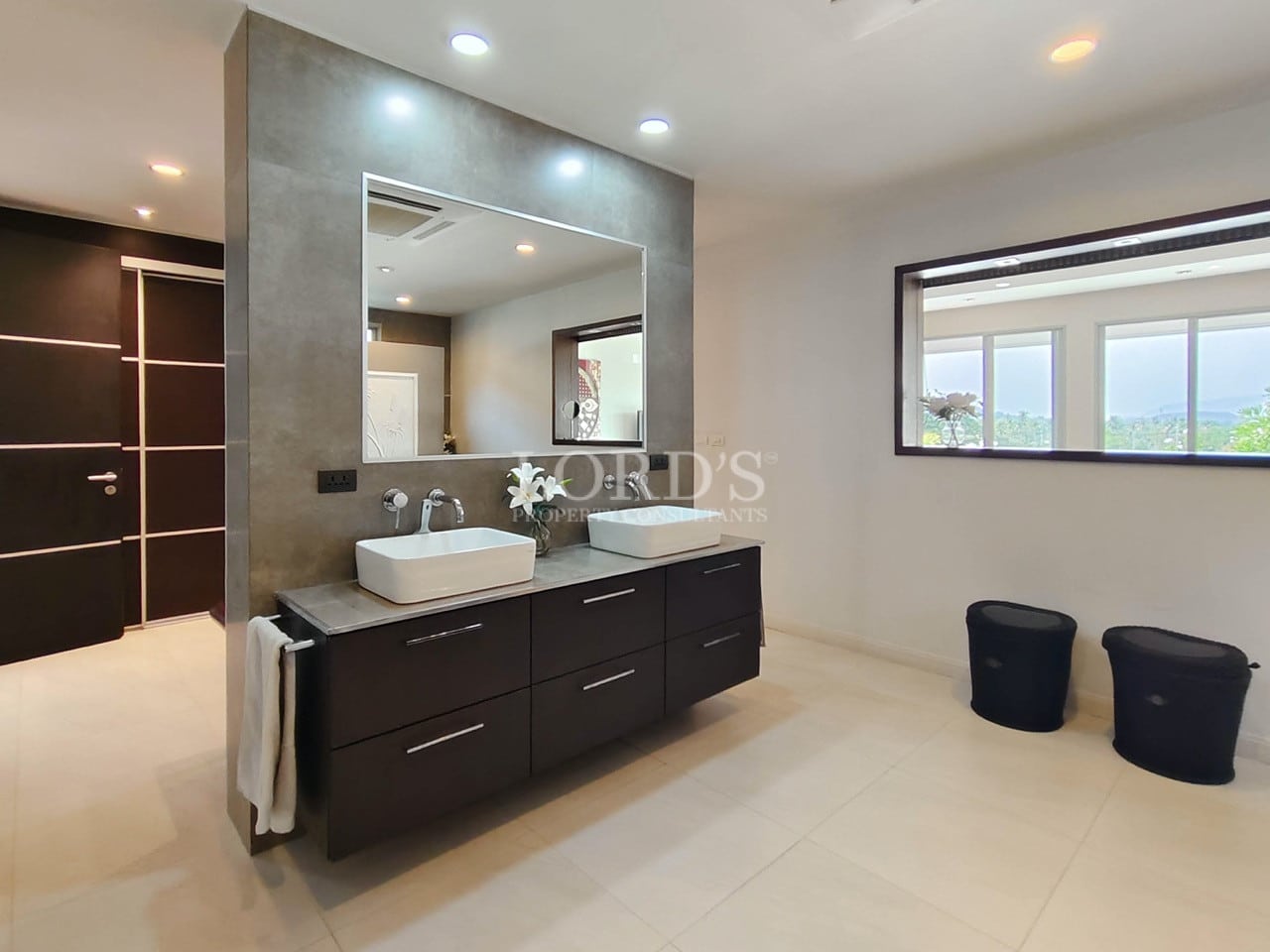 Luxury villa bathroom with double sink vanity, large mirror, and modern finishes.