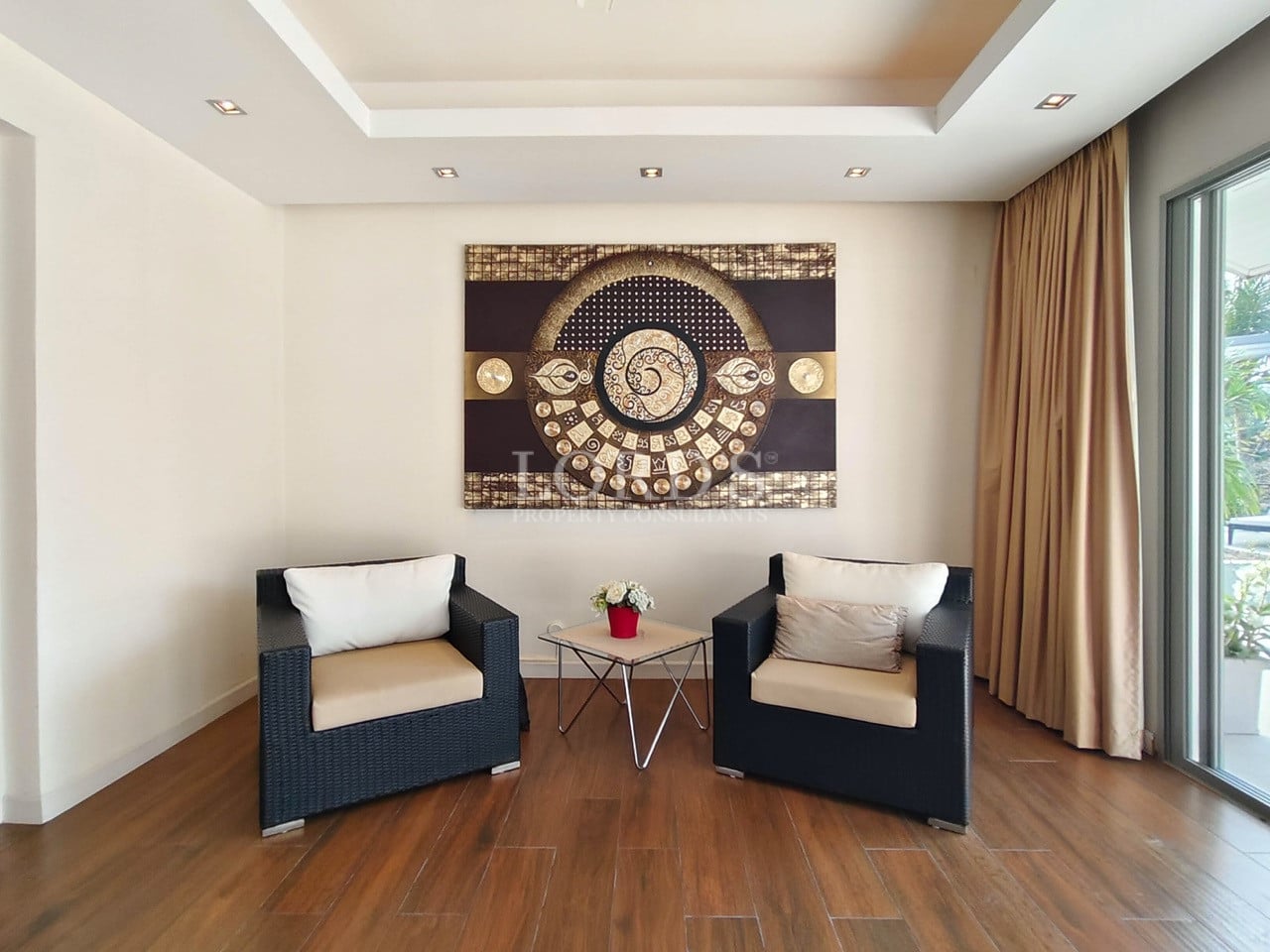 Private bedroom seating area with armchairs, wooden flooring, and decorative wall art.