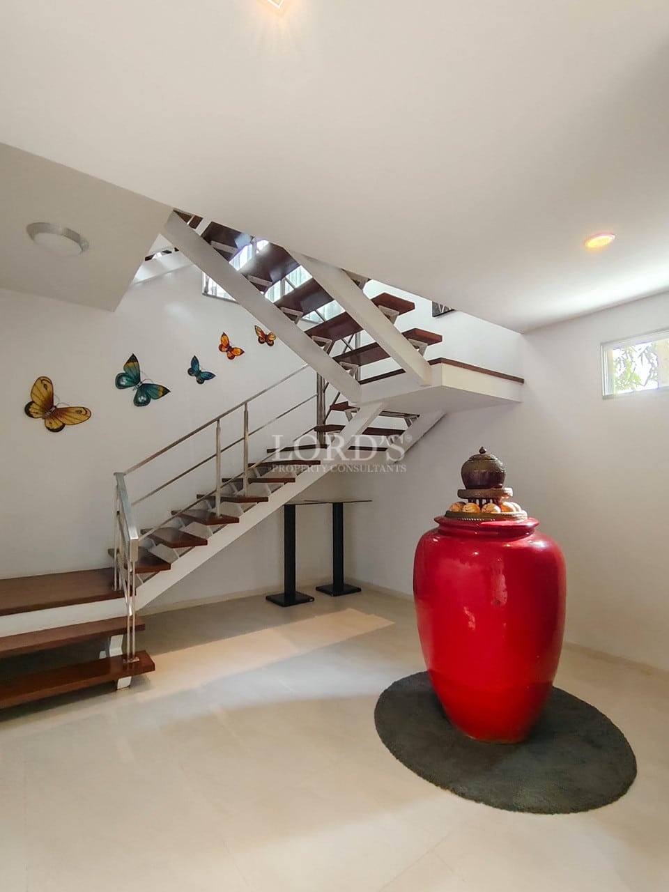 Modern villa staircase area with wooden steps and decorative centerpiece.