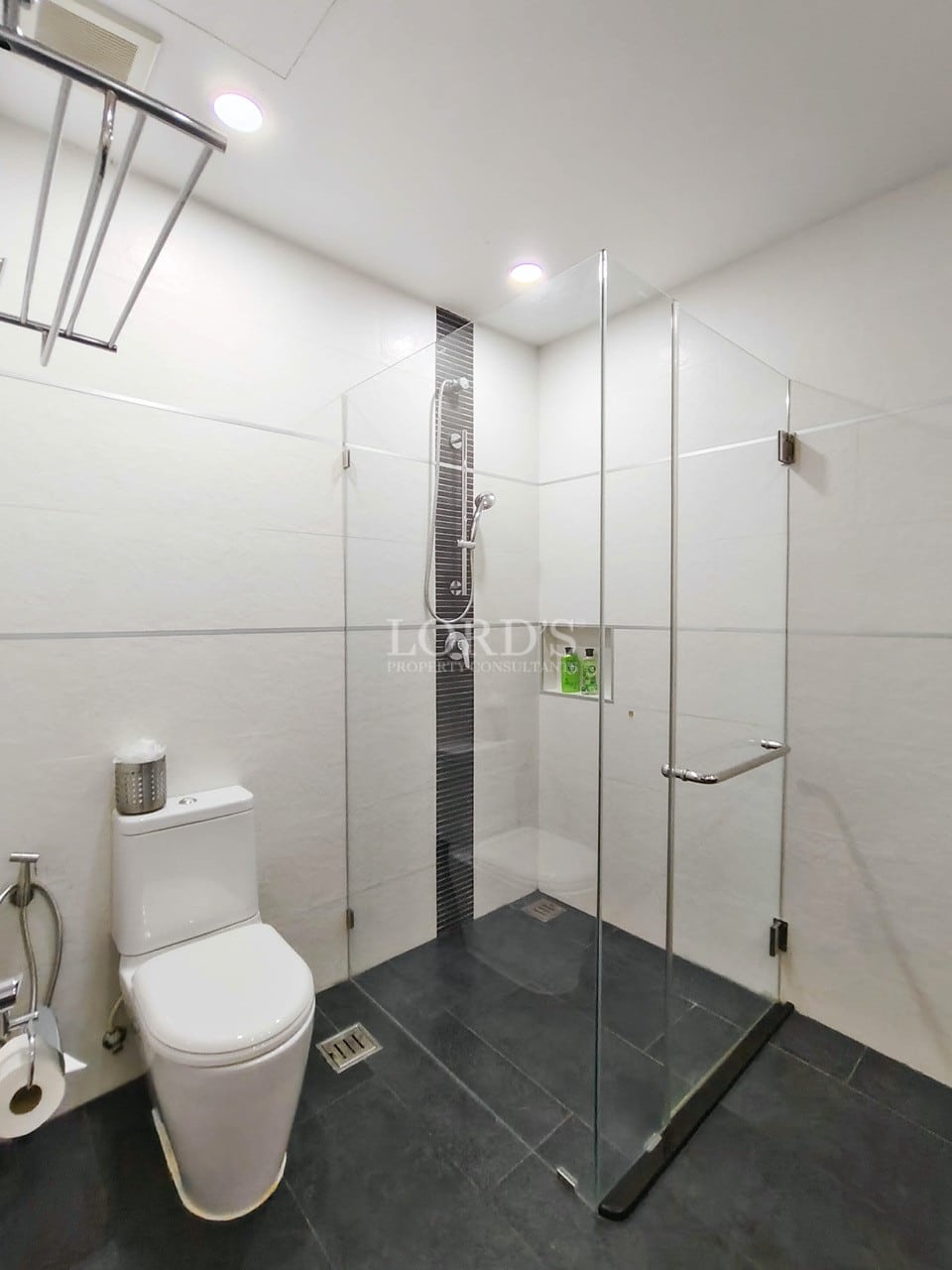 Modern villa bathroom with walk-in glass shower and minimalist white design.
