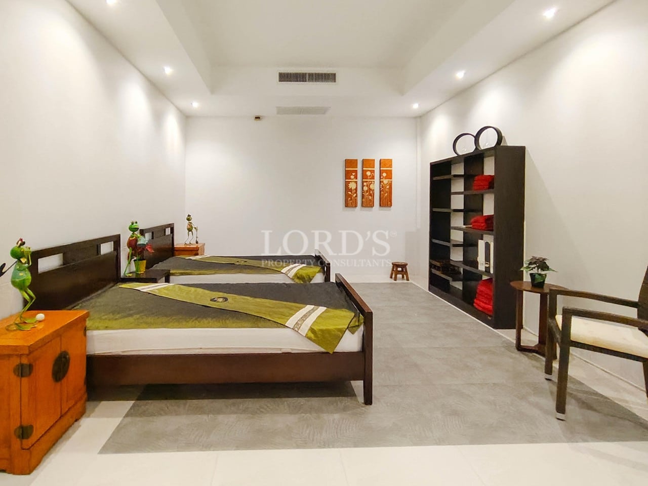 Modern villa bedroom with twin beds and minimalist interior design.