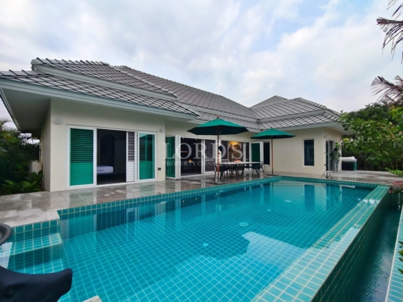 Modern single-story pool villa with private swimming pool, tiled roof, and outdoor patio seating