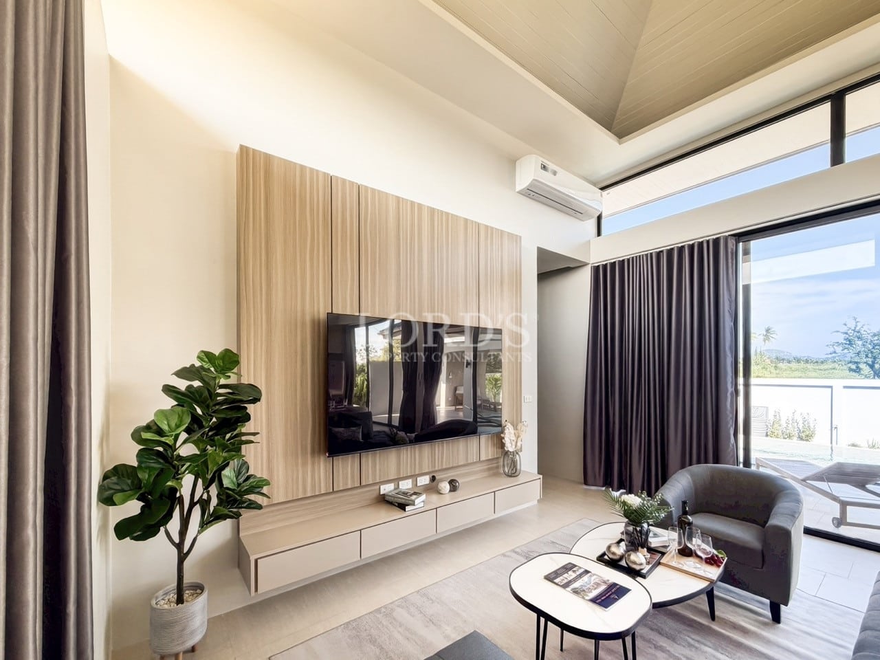 Modern living room with wall-mounted TV, wooden panel feature wall, and large glass doors
