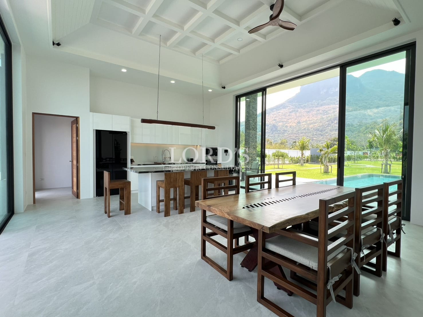Open-plan dining and kitchen area with large sliding glass doors and mountain views.