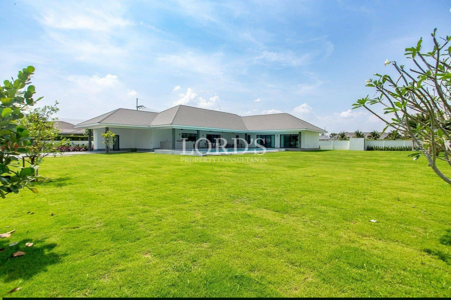 Luxury single-story modern villa with large green lawn and private outdoor space