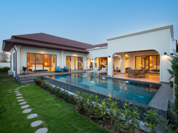 Modern luxury villa with private swimming pool, landscaped garden, and outdoor dining terrace at dusk.