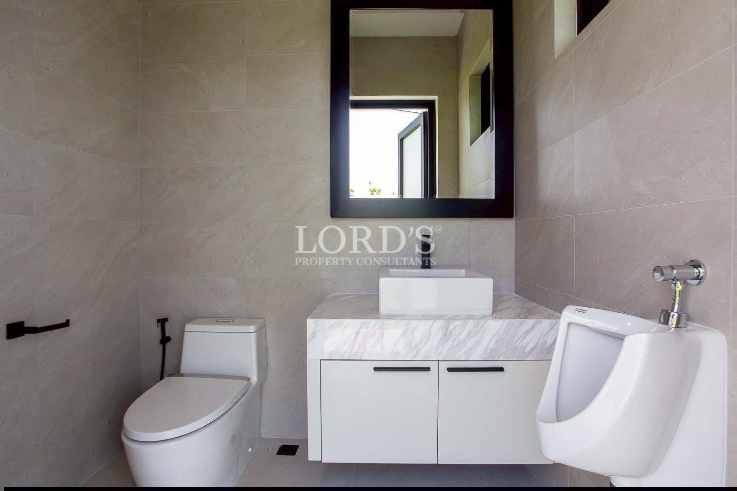 Modern bathroom with wall-mounted vanity, vessel sink, toilet, and urinal.