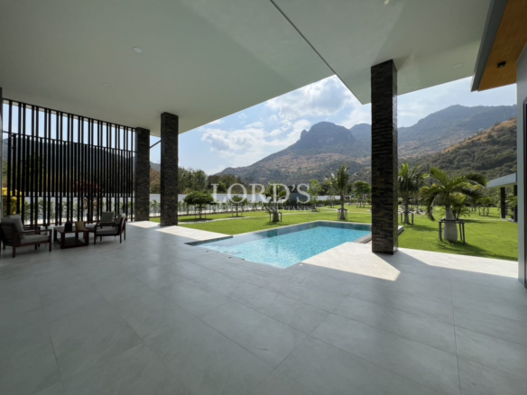 Covered outdoor terrace with swimming pool, landscaped garden, and mountain views.