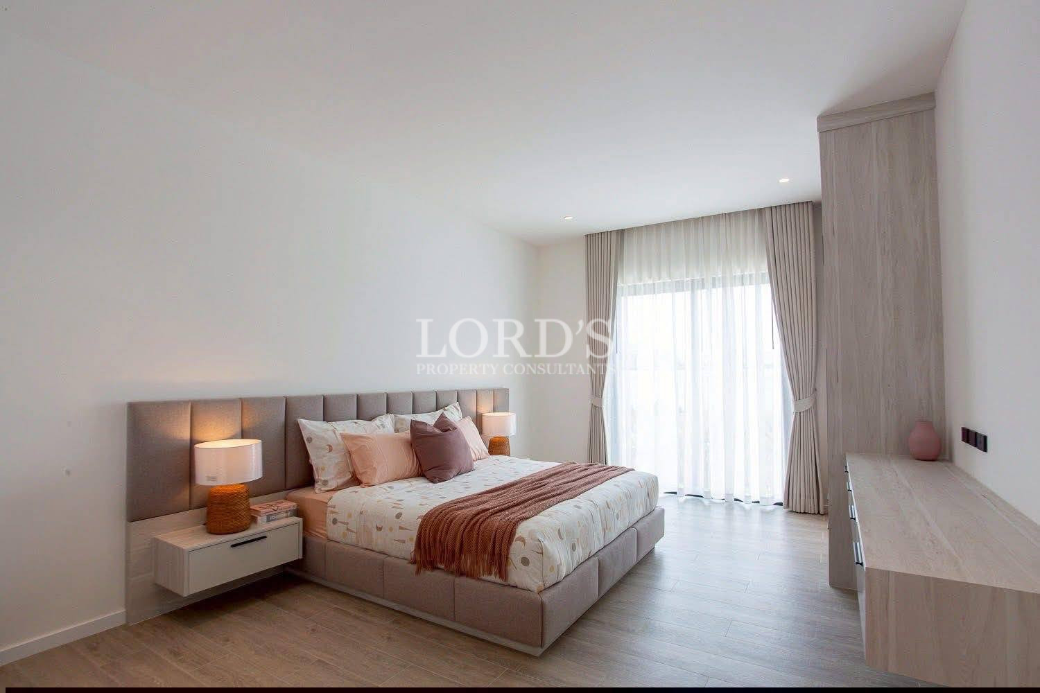 Minimalist modern bedroom with upholstered bed, floating nightstands, and large curtained window.