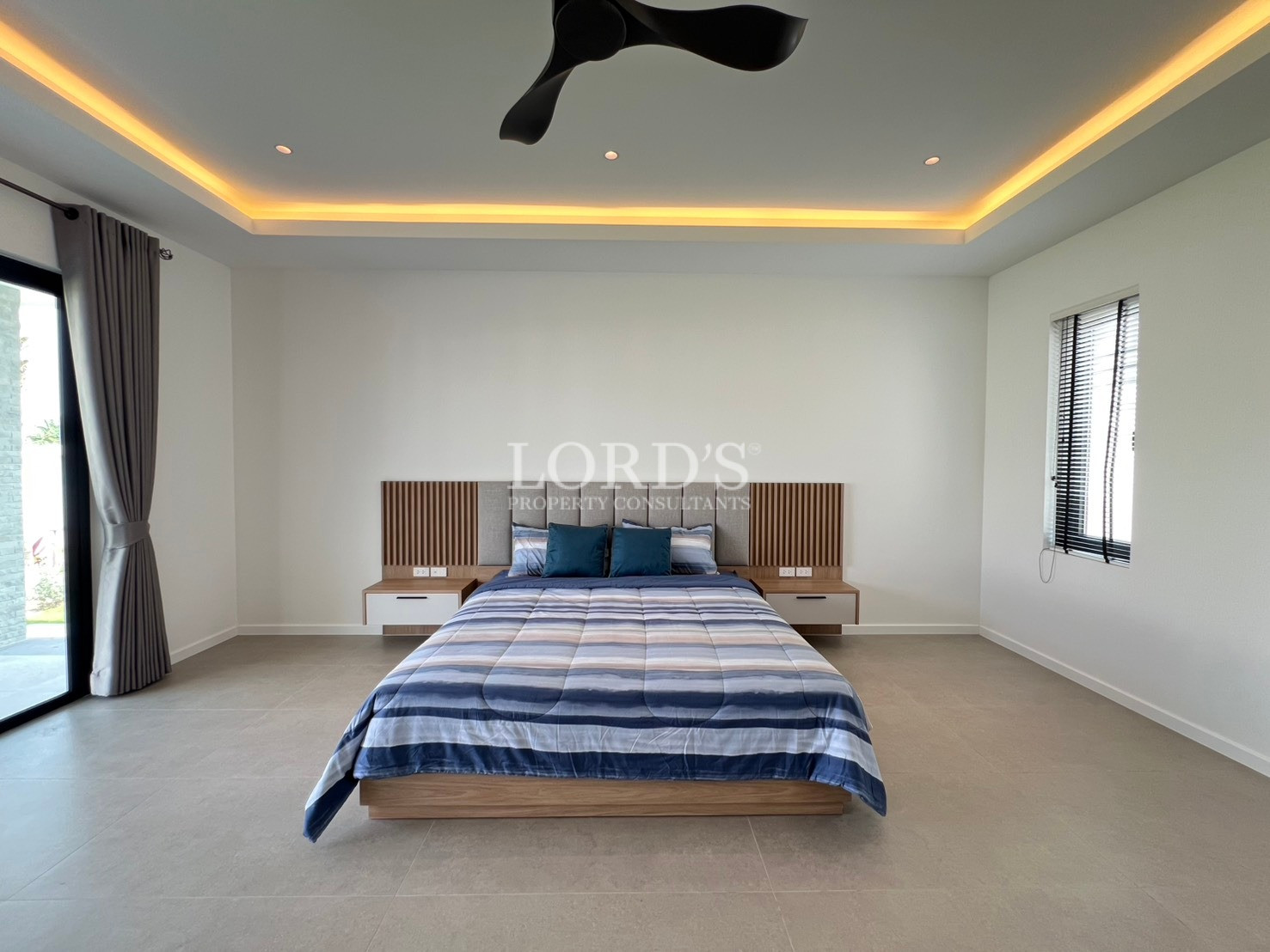 Minimalist modern bedroom with central bed, floating nightstands, and warm ceiling lighting.