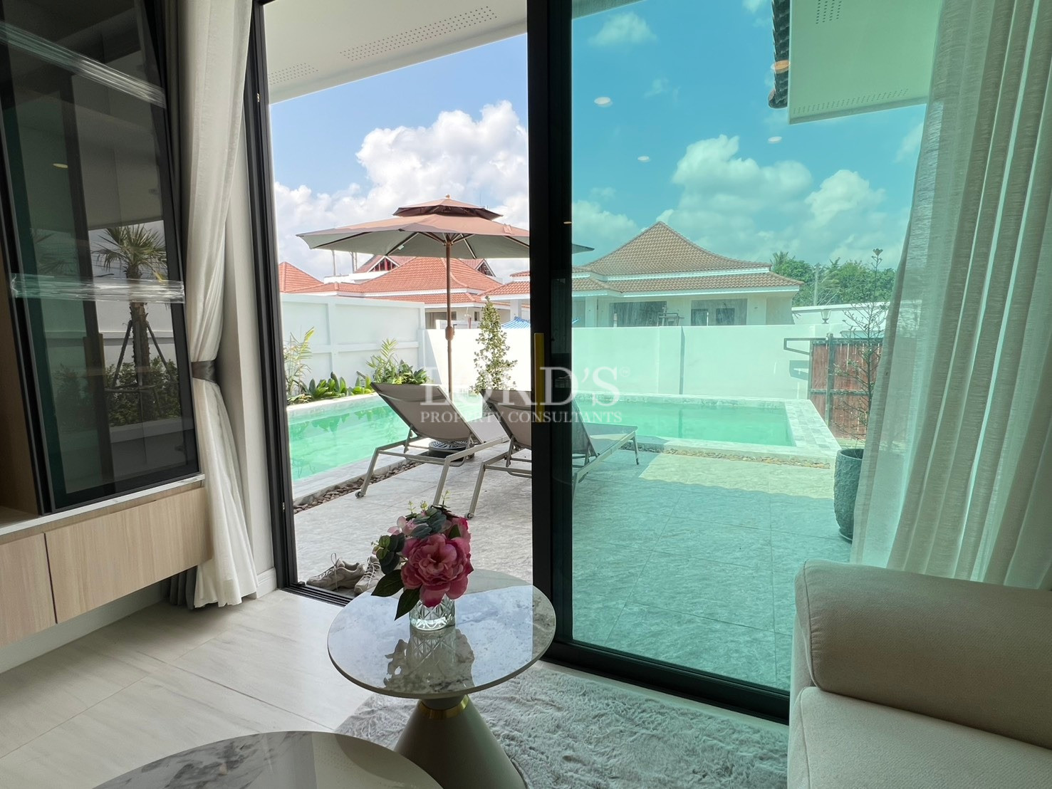 View from living area to private swimming pool through sliding glass doors.