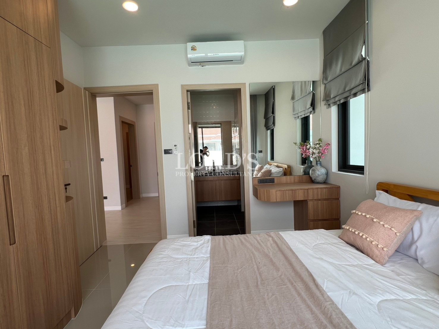 Modern bedroom with ensuite bathroom access, built-in wardrobe, and vanity desk.