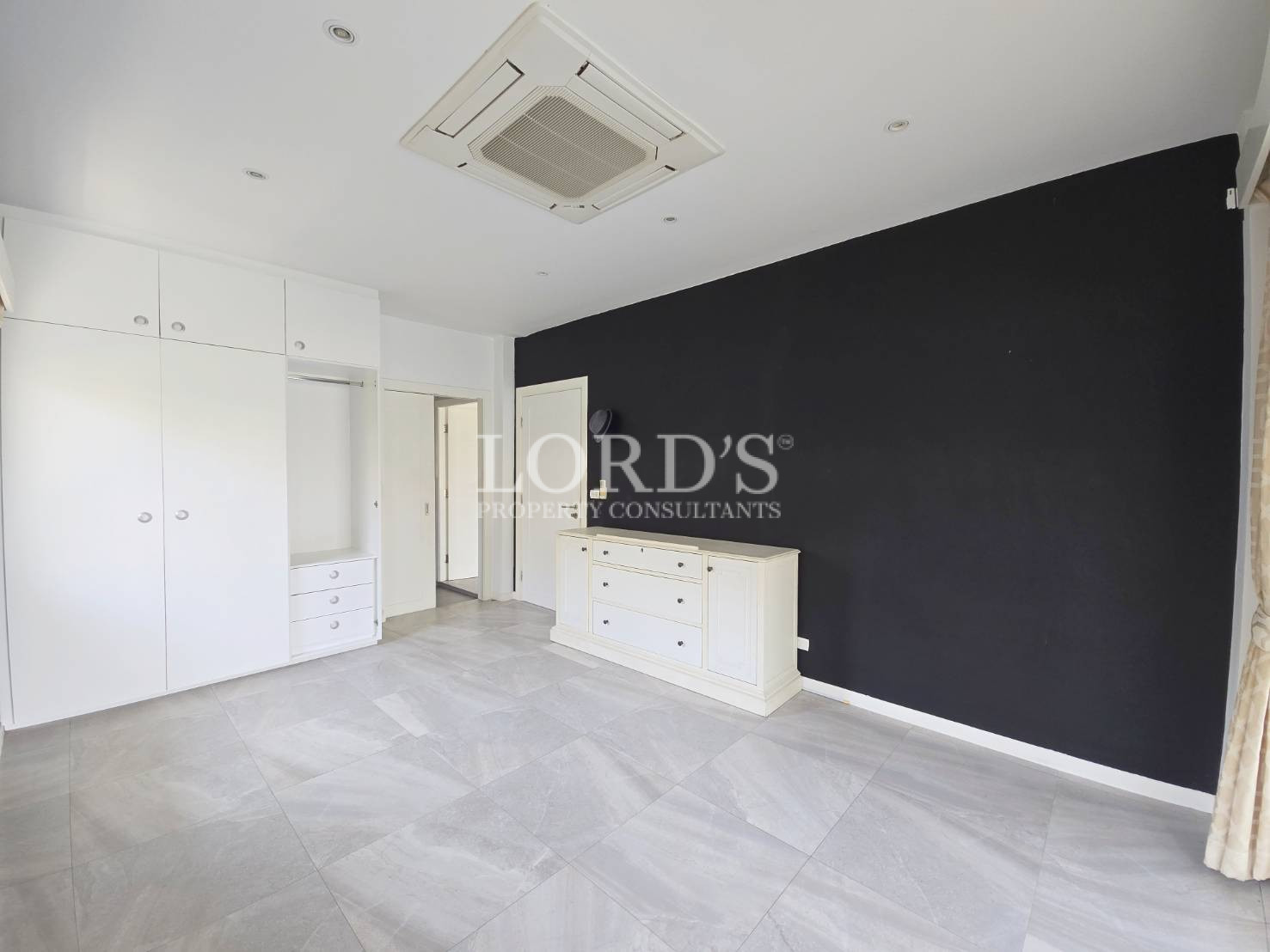 Kitchen with white cabinets and black wall