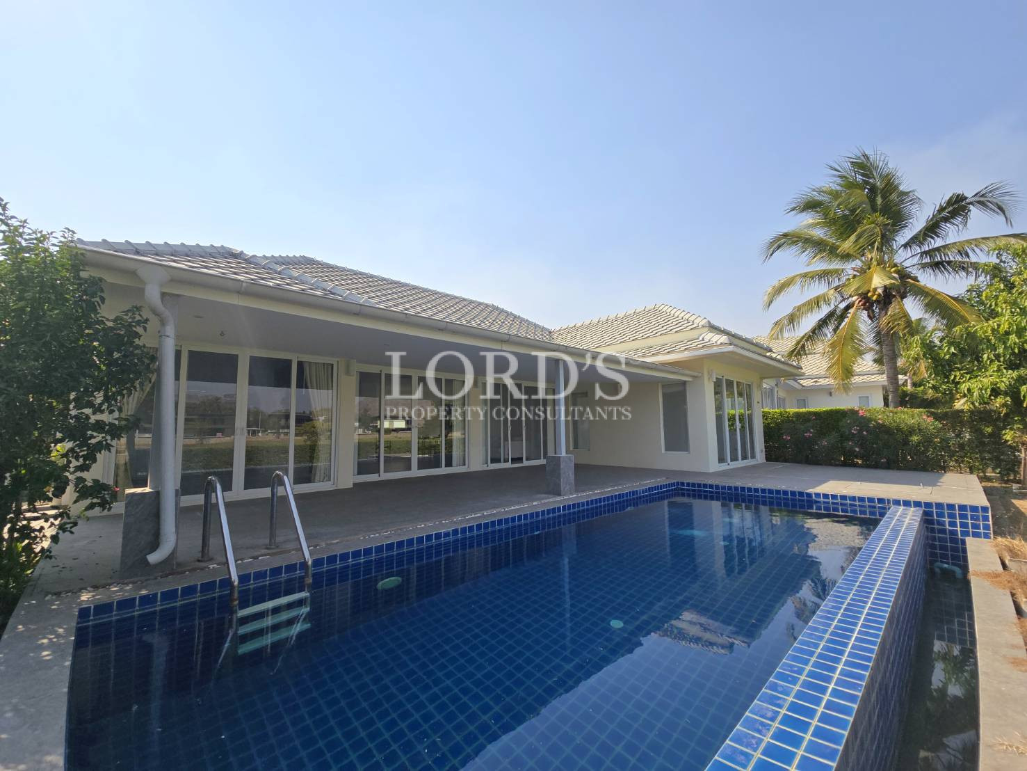 Pool beside house with covered patio