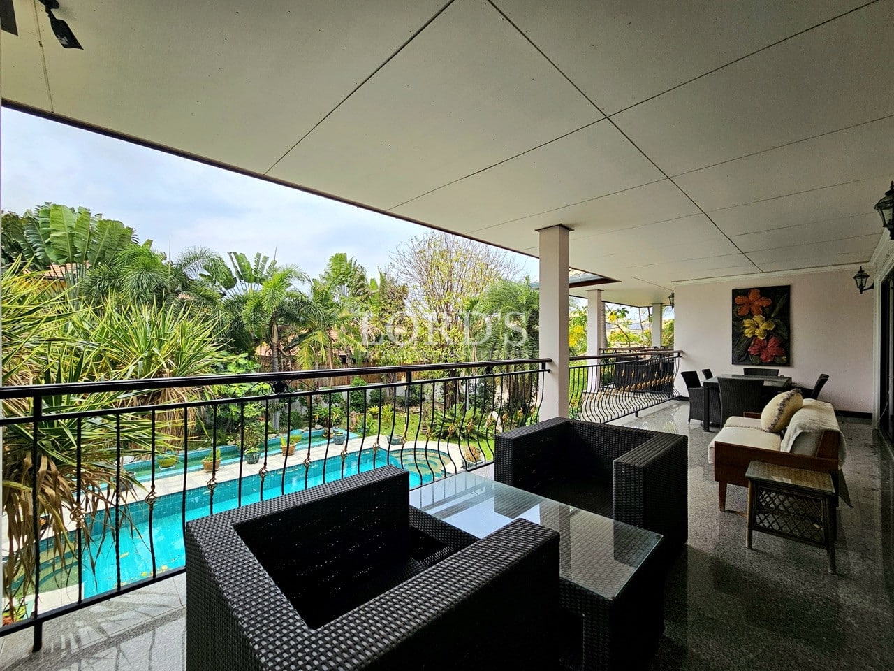 Outdoor lounge seating area on balcony with pool view
