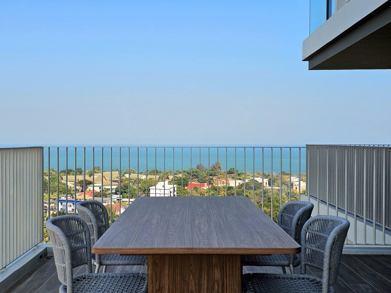 Balcony with table and chairs overlooking sea