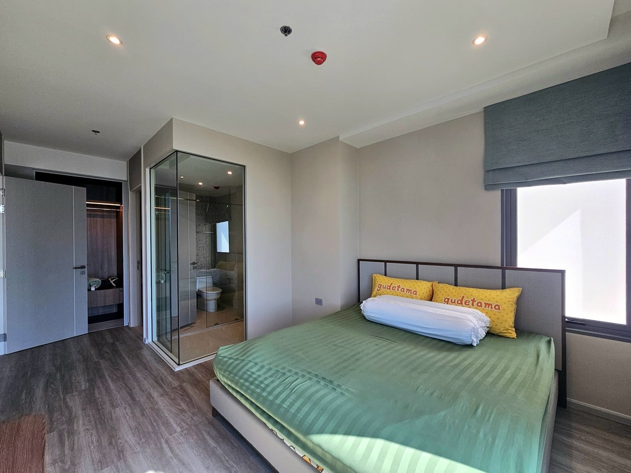 Bedroom with green bed and balcony access