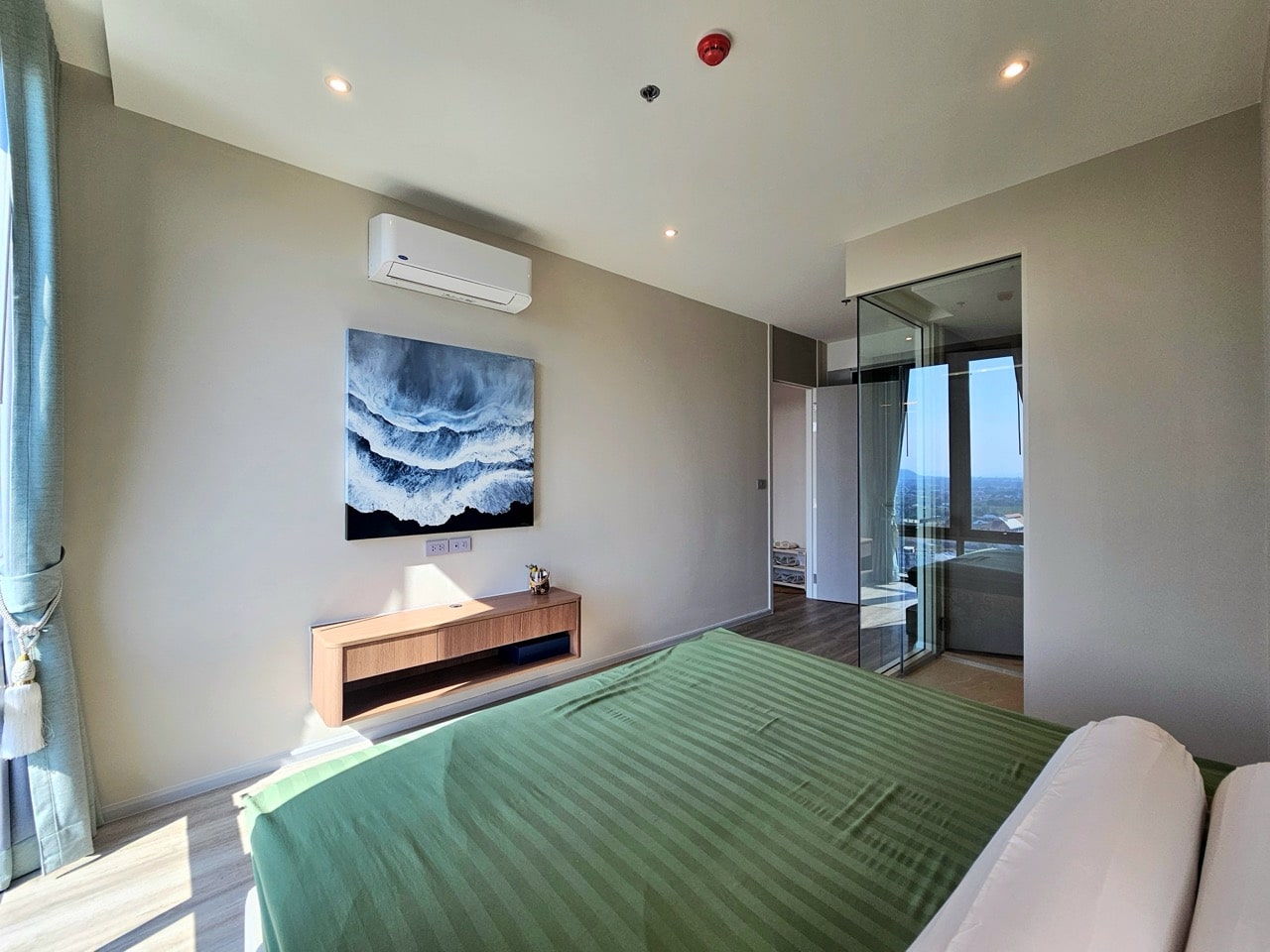 Bedroom with green bedding and TV unit