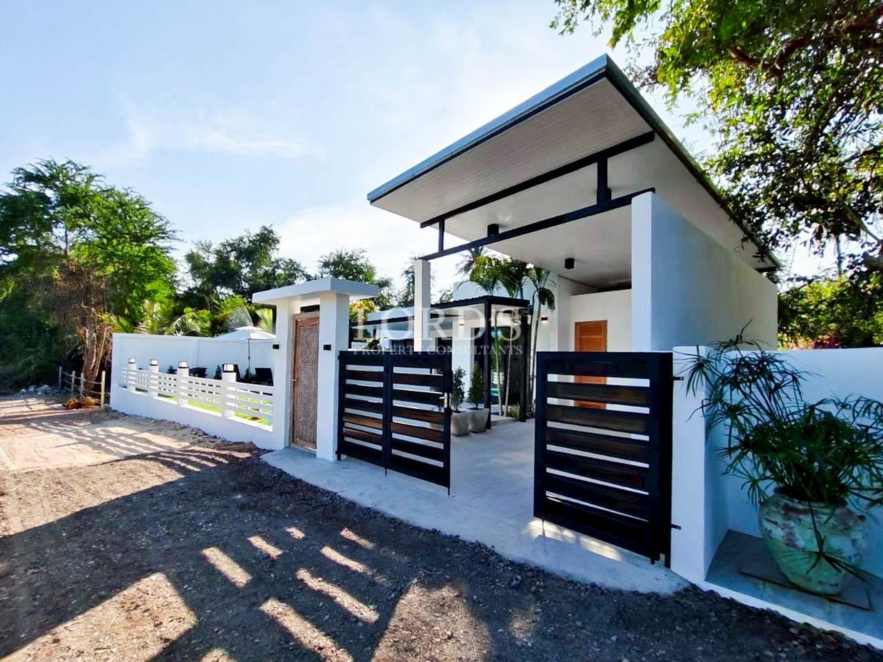 Contemporary villa entrance with modern gate and driveway