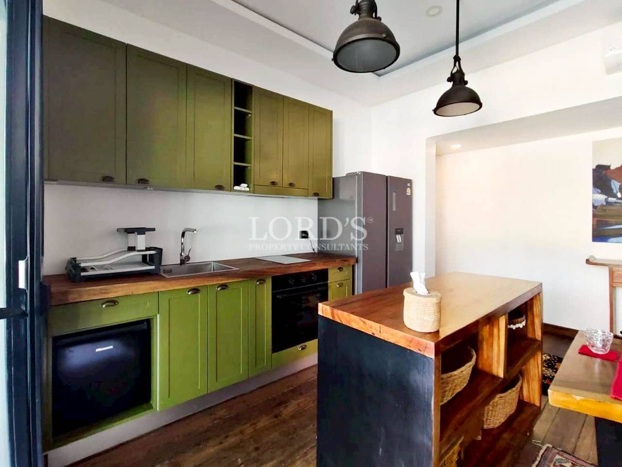 Contemporary kitchen with green cabinets and island counter