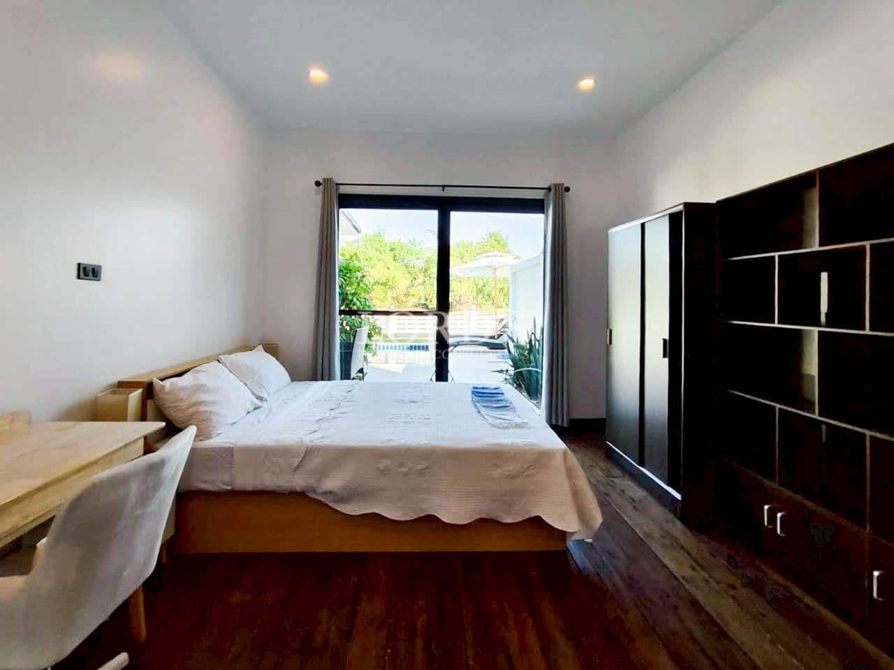 Bedroom with wooden floor and balcony access