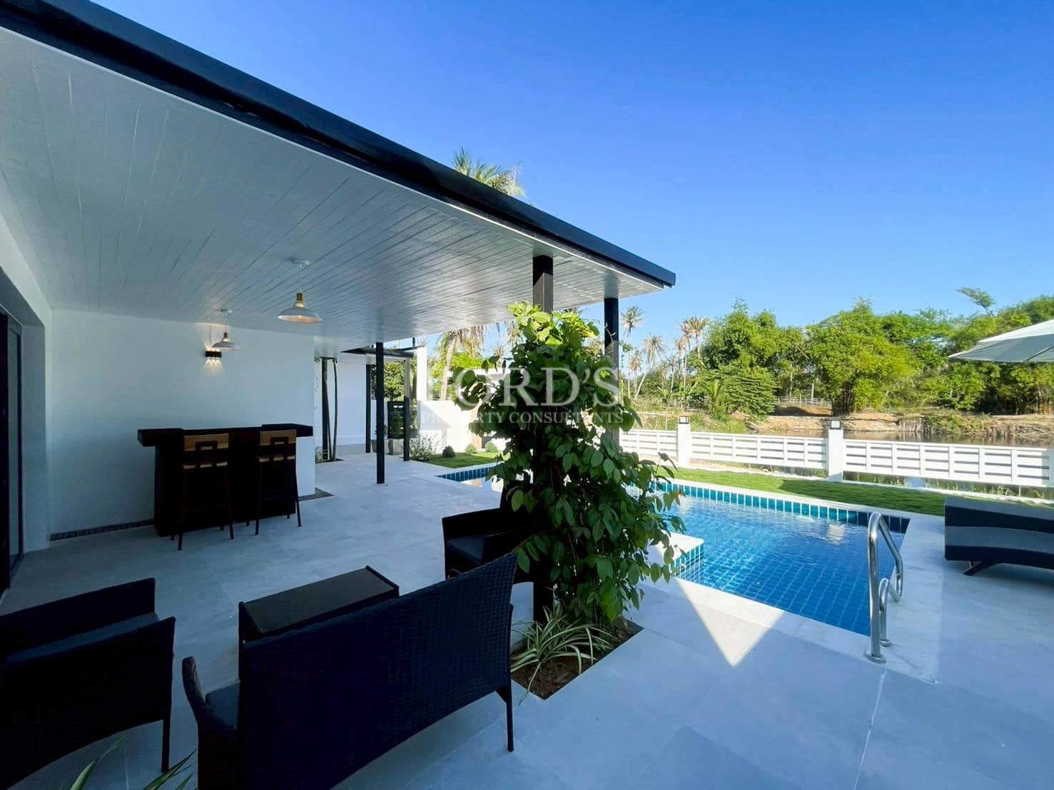 Private pool area beside modern white villa architecture