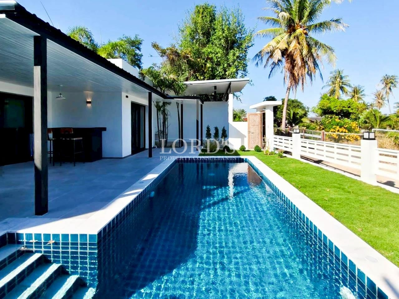 Long swimming pool beside modern villa structure