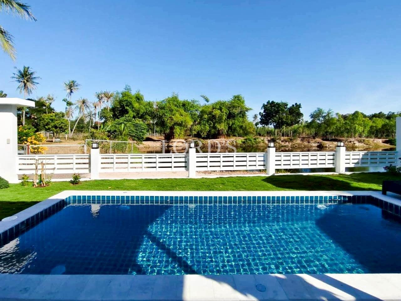 Blue tiled swimming pool with outdoor relaxation area