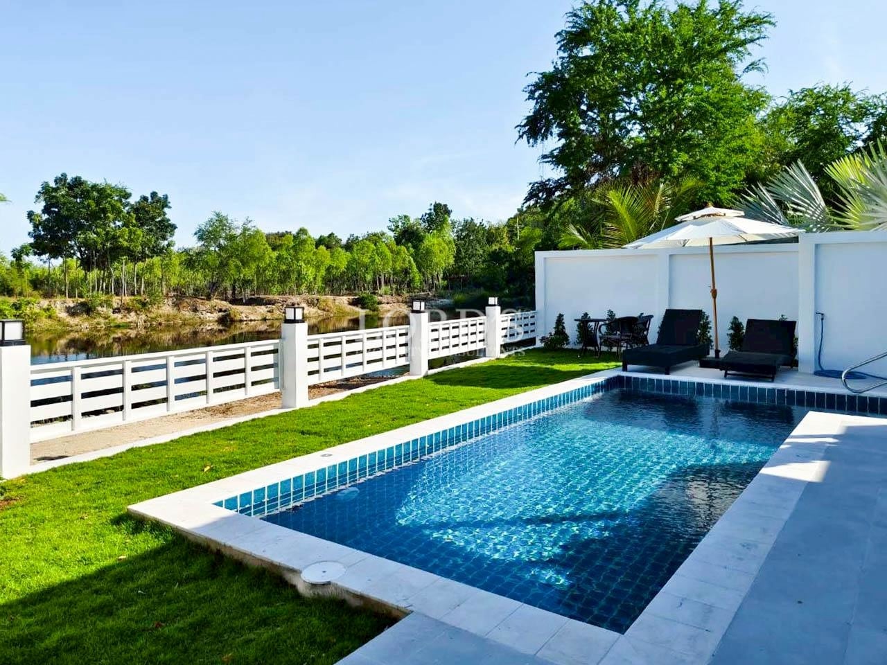 Modern rectangular swimming pool with white fence