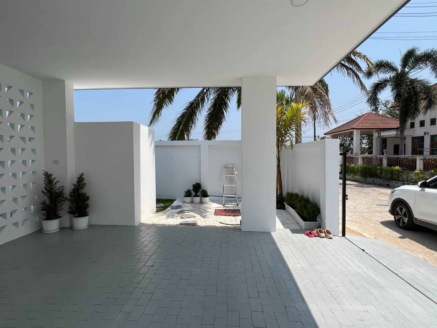 Covered outdoor parking area with tiled floor