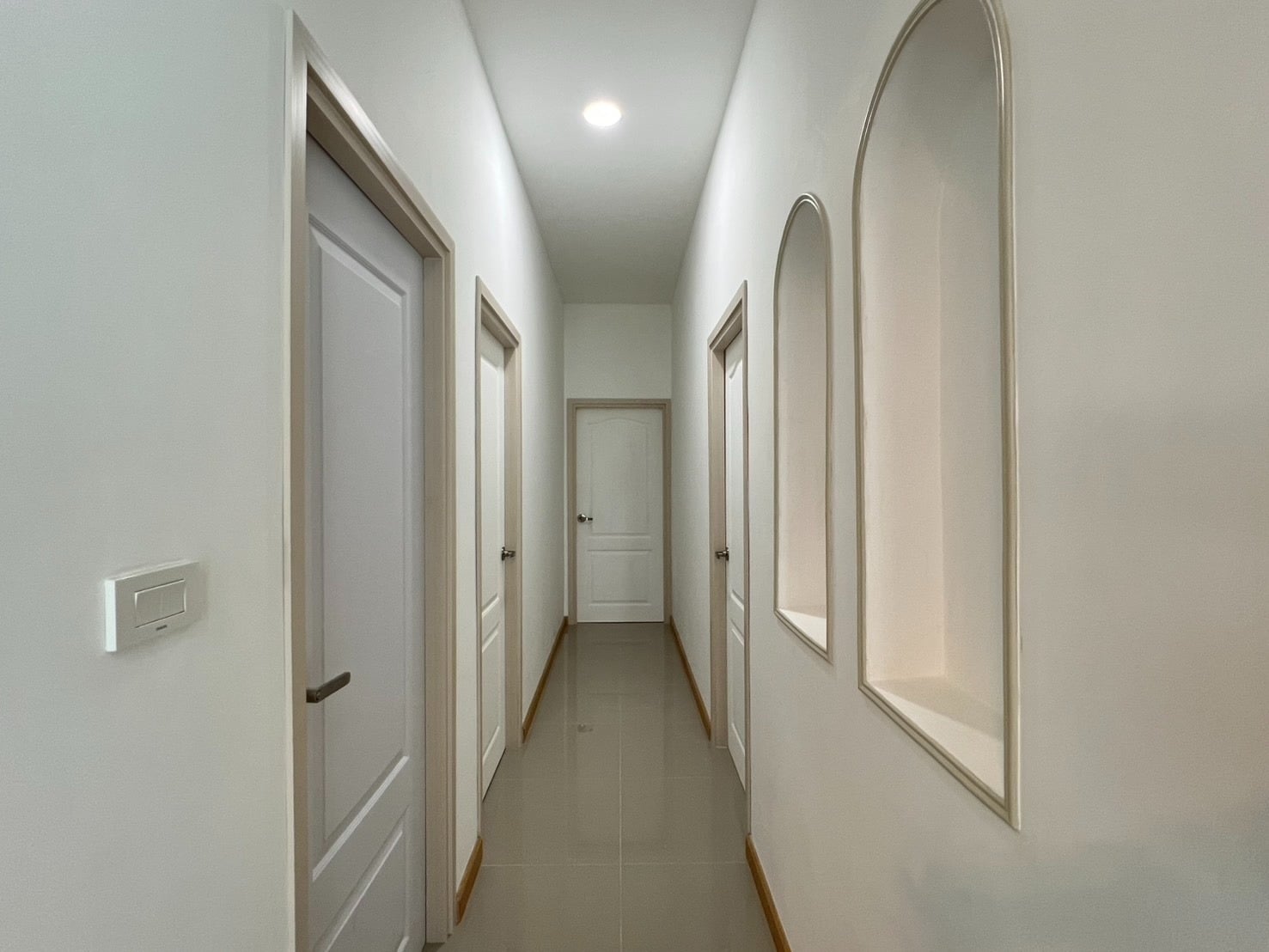 Hallway with arched wall design and lighting