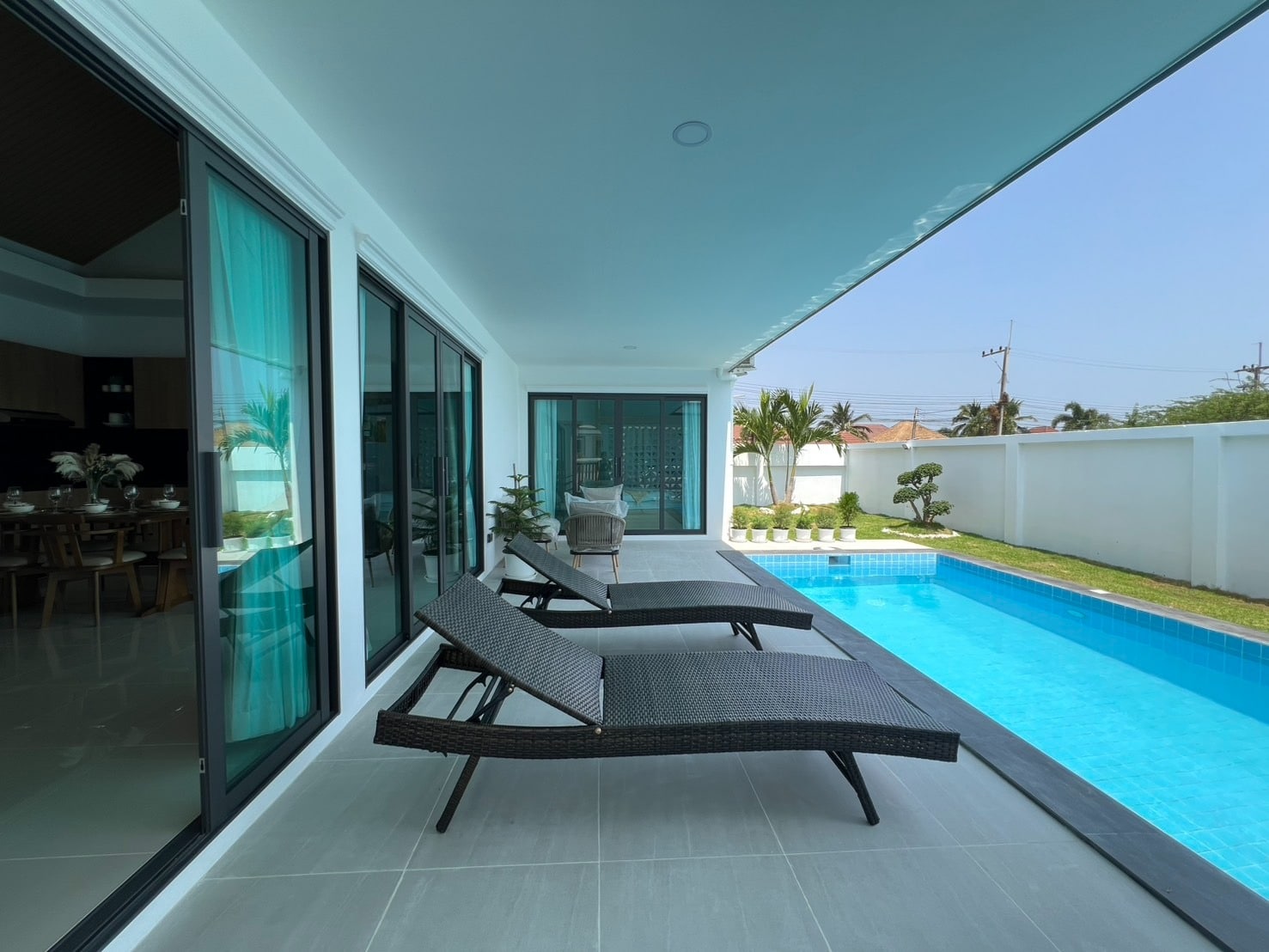 Long swimming pool with deck chairs