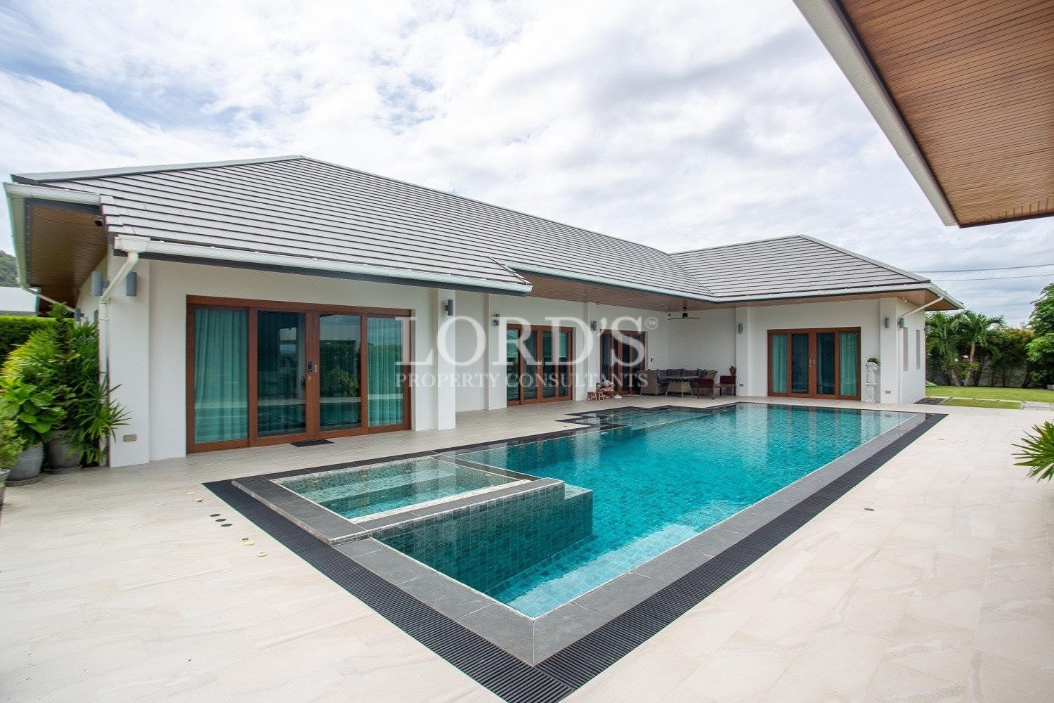 Pool with tiled edge and house view