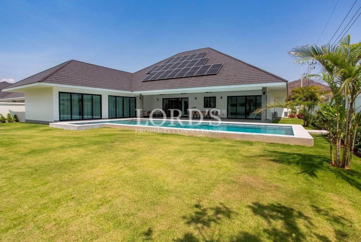 Modern single-story villa with landscaped lawn and solar panels